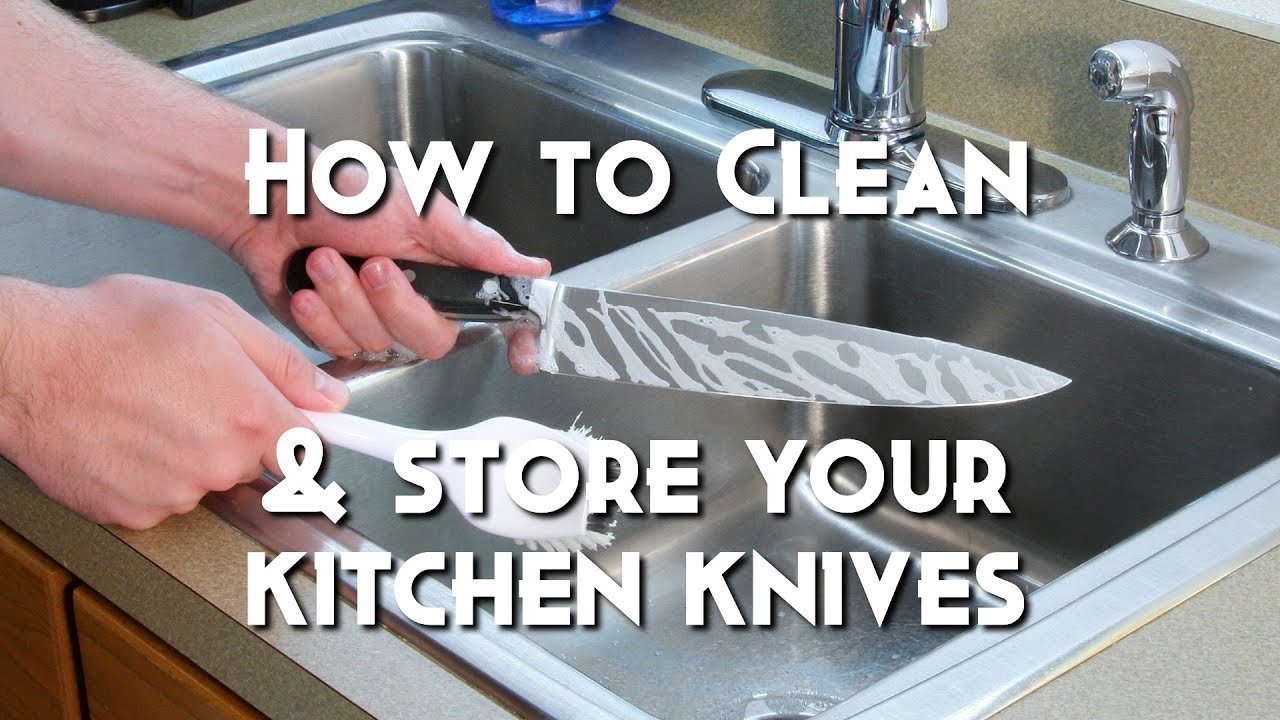 Rinsing a kitchen knife under warm running water to remove food debris.