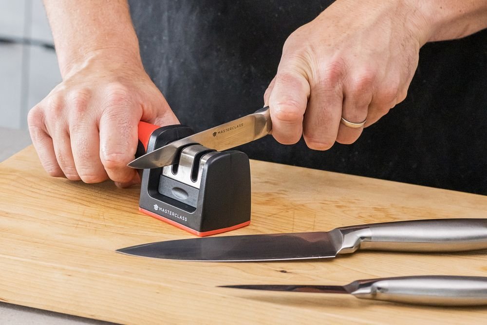Western and Japanese kitchen knife blades displayed side by side on a board.