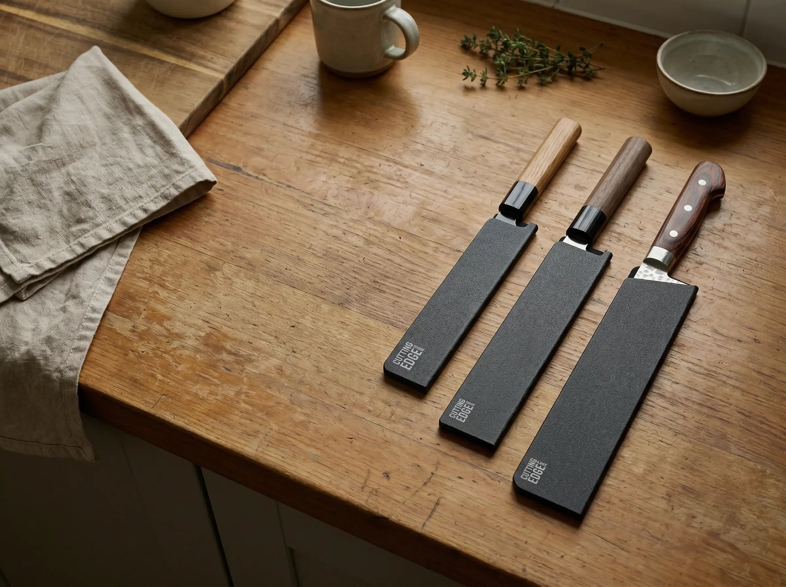 Person sharpening a kitchen knife on a wet whetstone with precise technique.