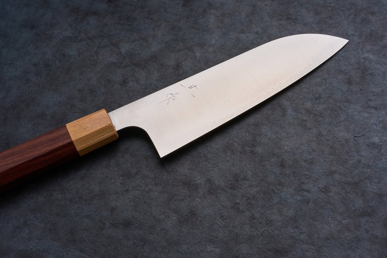A coarse whetstone used for repairing a chipped kitchen knife blade.